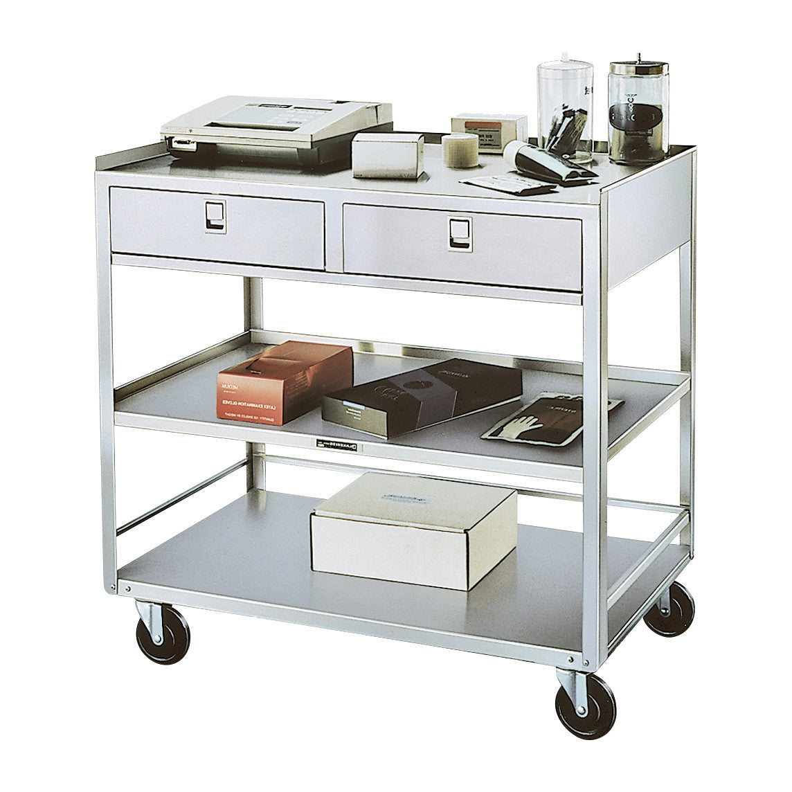 A Lakeside Stainless Steel Equipment Stand with two drawers and two shelves, holding boxes and office supplies on castor wheels.