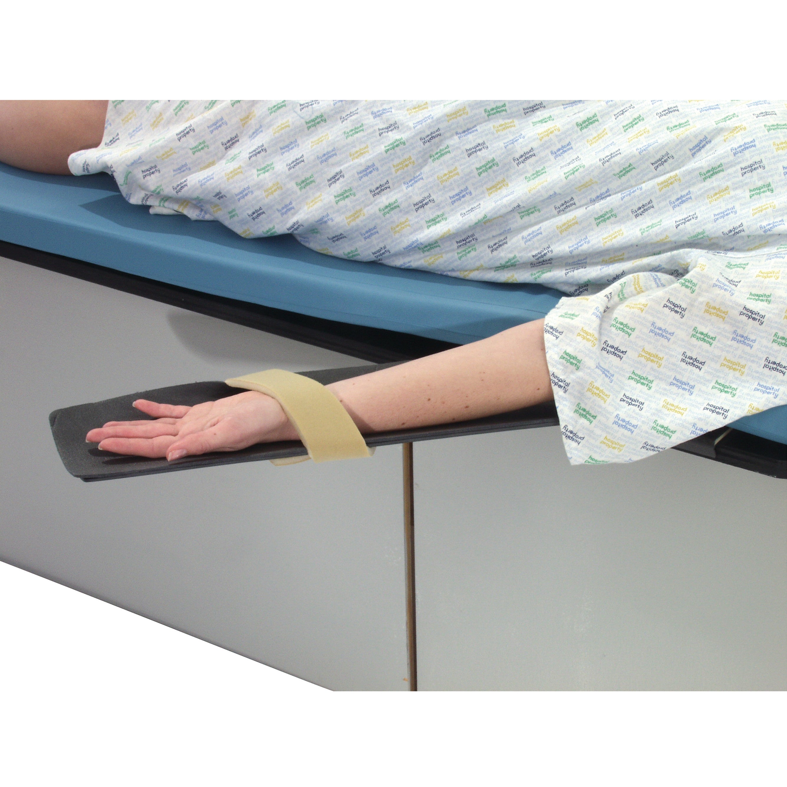 A patient on an Angiography Armboard with their arm secured by a strap, lying on a padded hospital table.