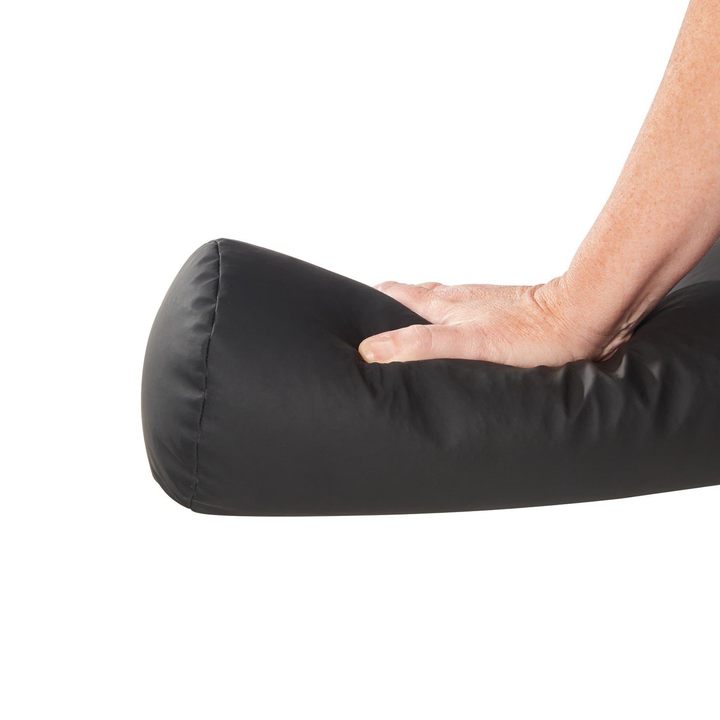 A hand presses on a black AliMed ComPly Chest Roll Positioner, showing its flexibility and cushioning.