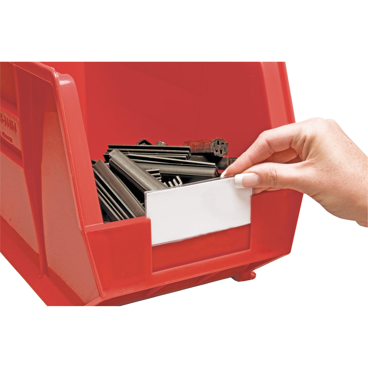 A hand places a Clear Label Holder and Insert on a red Quantum Ultra Stack and Hang Bin containing metal objects.