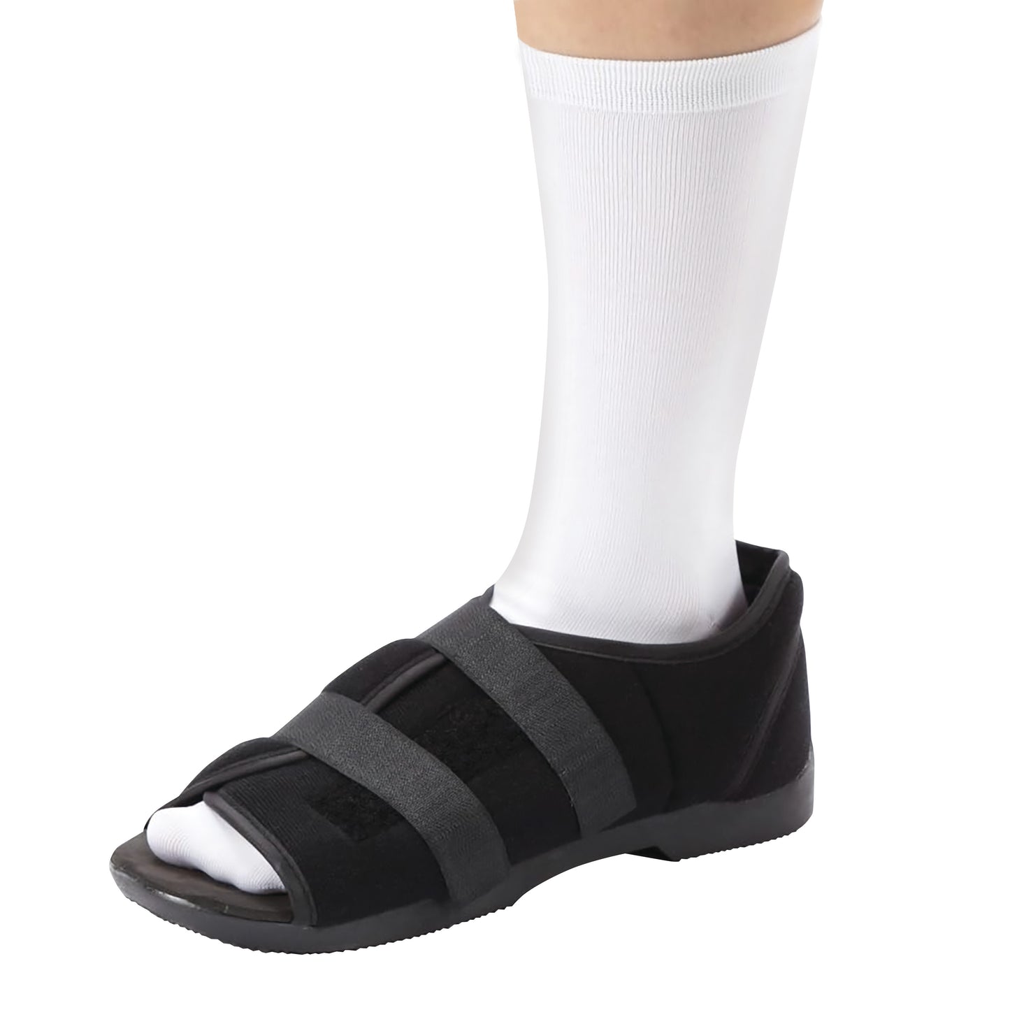 A DARCO Softie Shoe fits a foot wearing a white sock. The black shoe has two adjustable straps and a slightly raised heel.