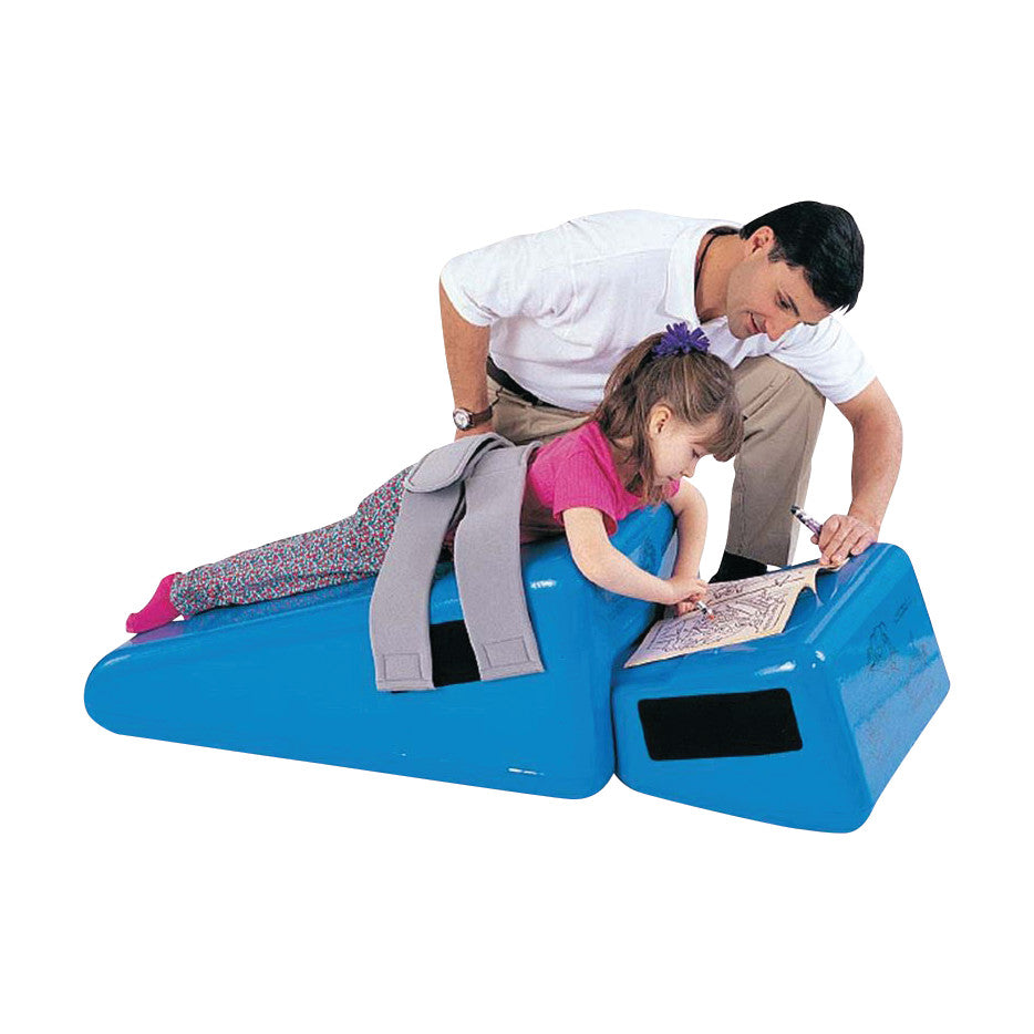 A child uses the Tumble Forms2 Adolescent Thera-Wedge System for support while coloring. An adult assists beside her.