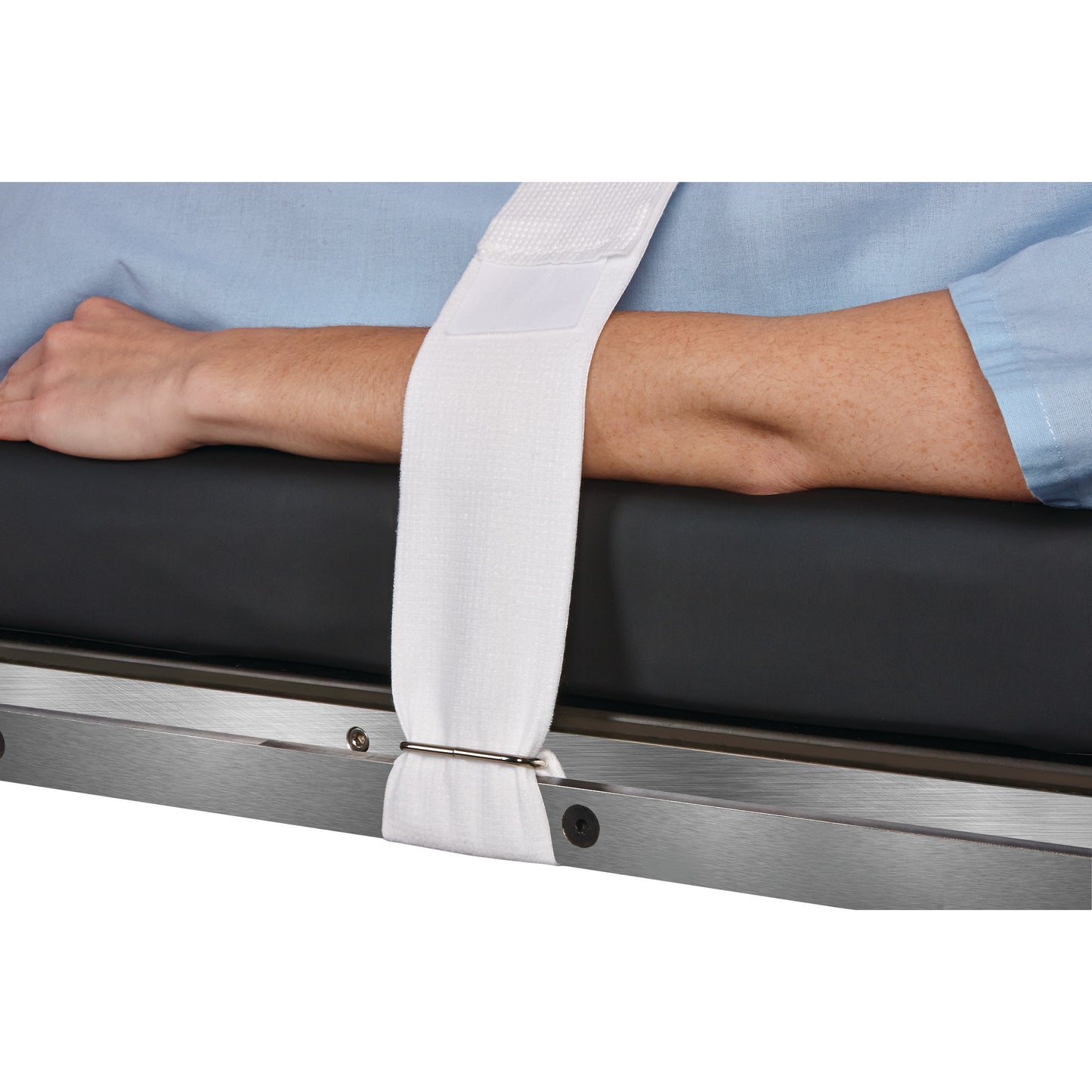 A person's arm is secured with a Halyard Operating Room Table/Stretcher Strap, which is attached to the side of a medical bed.