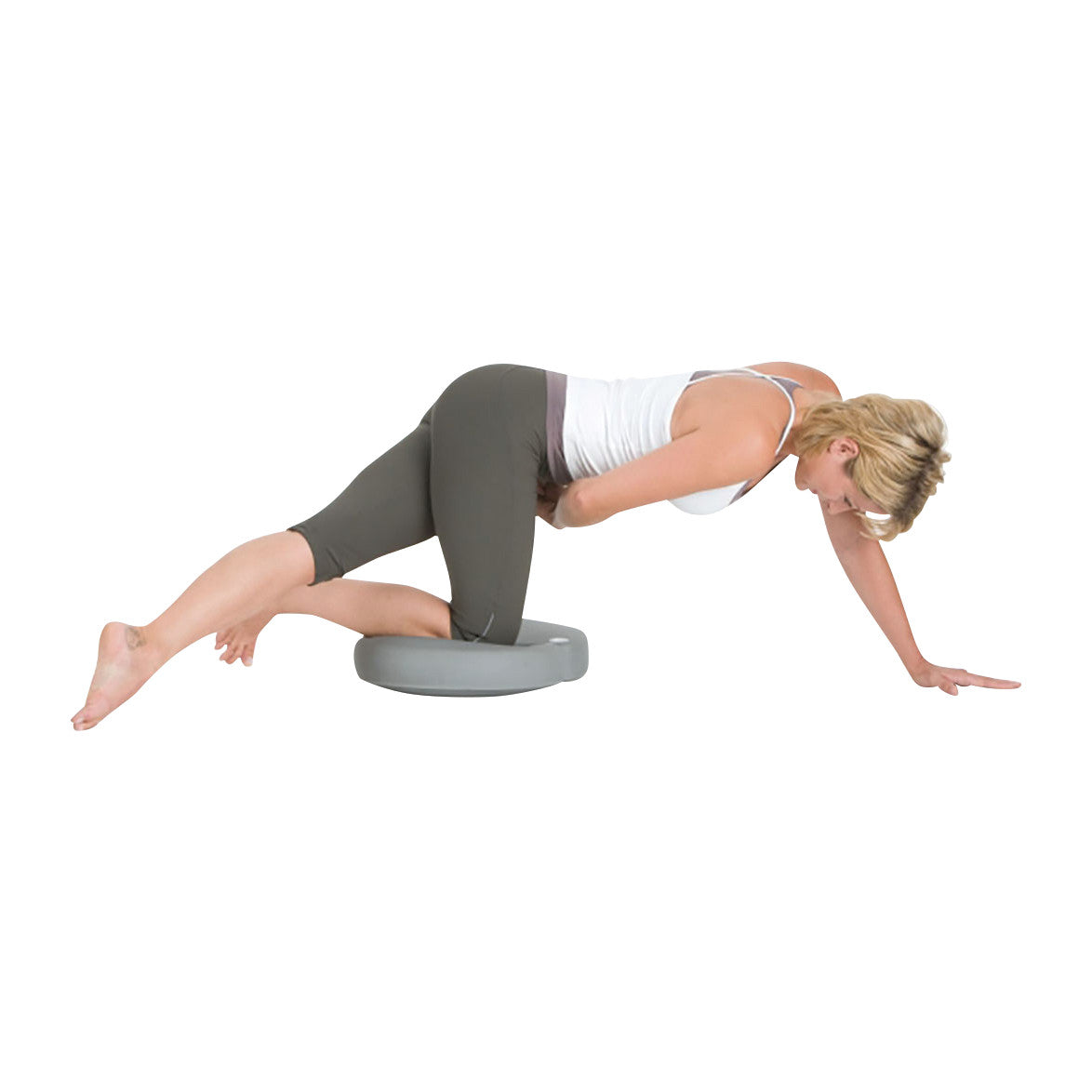 A woman exercises using the TOGU Aero-Step XL Functional, balancing on one knee with arms extended for stability.