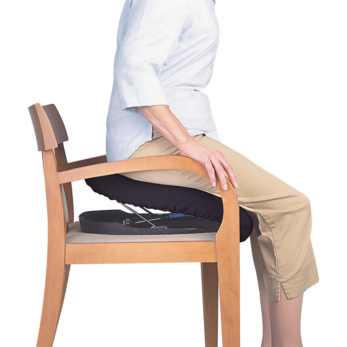 A person sits on a chair using the Carex Uplift Seat Assist, which helps them rise more easily.