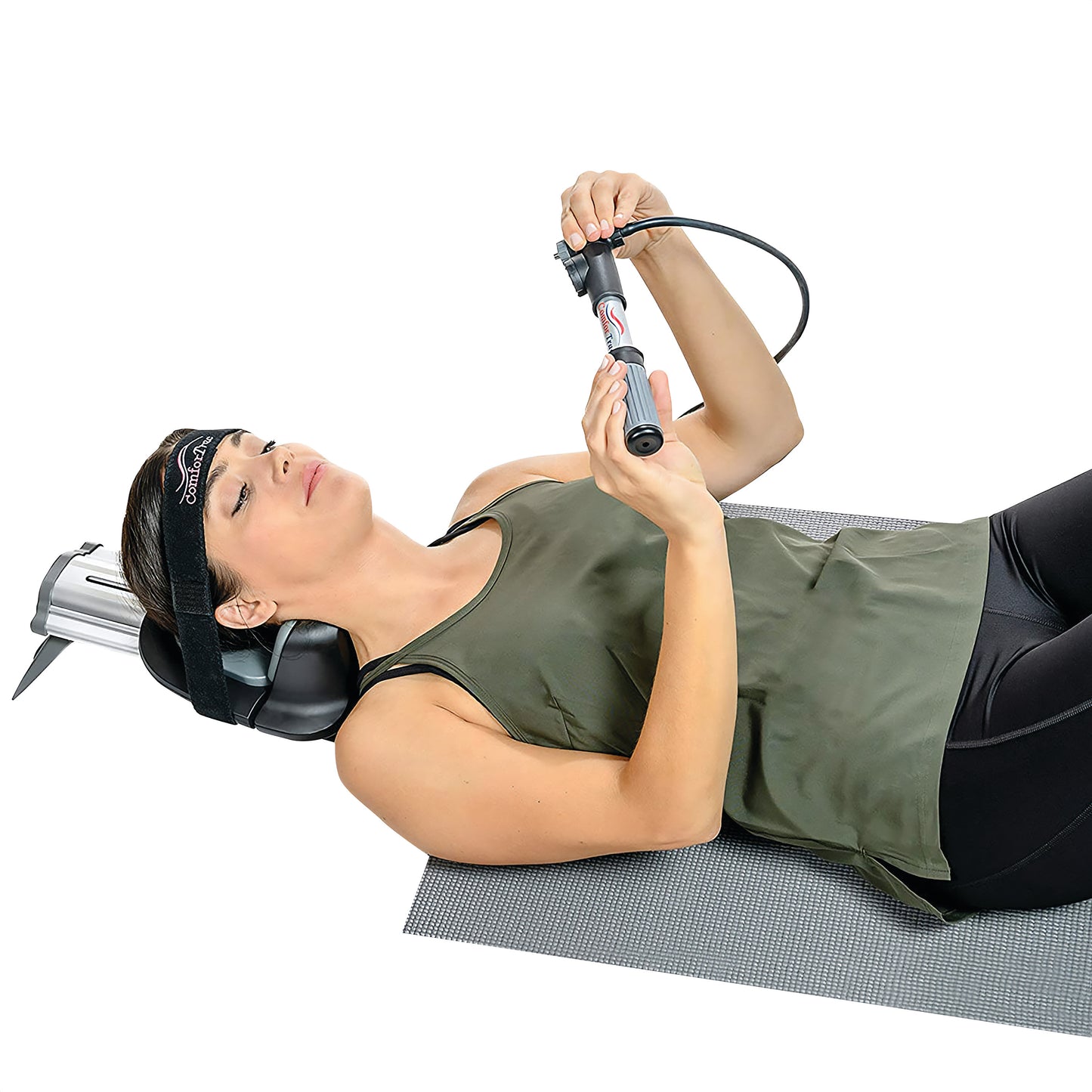 A woman uses the ComforTrac Cervical Traction Unit while lying on a mat, adjusting it with a handheld pump.