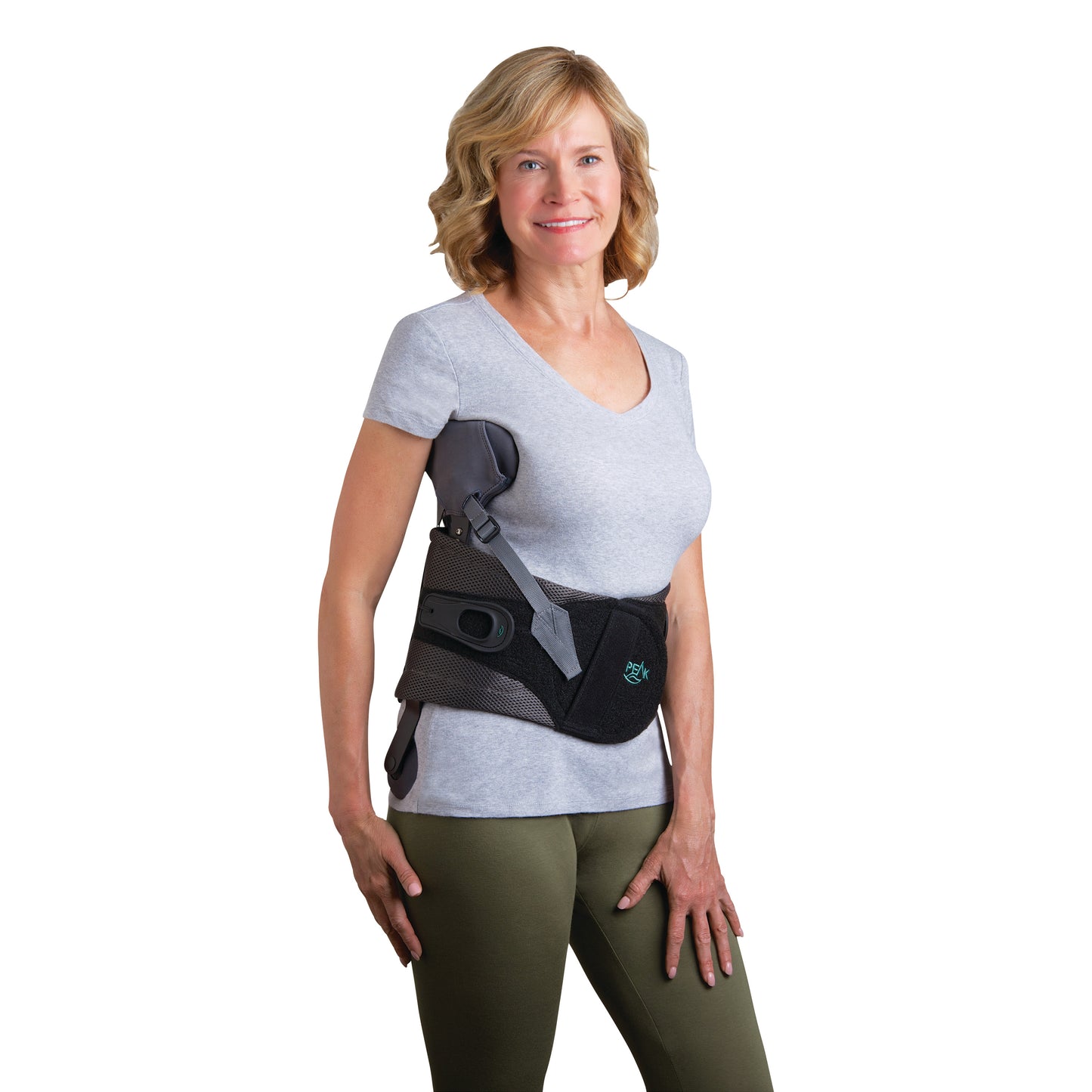 A person wearing the Peak Adjustable Scoliosis Bracing System, featuring adjustable straps and a support belt, over a grey shirt.