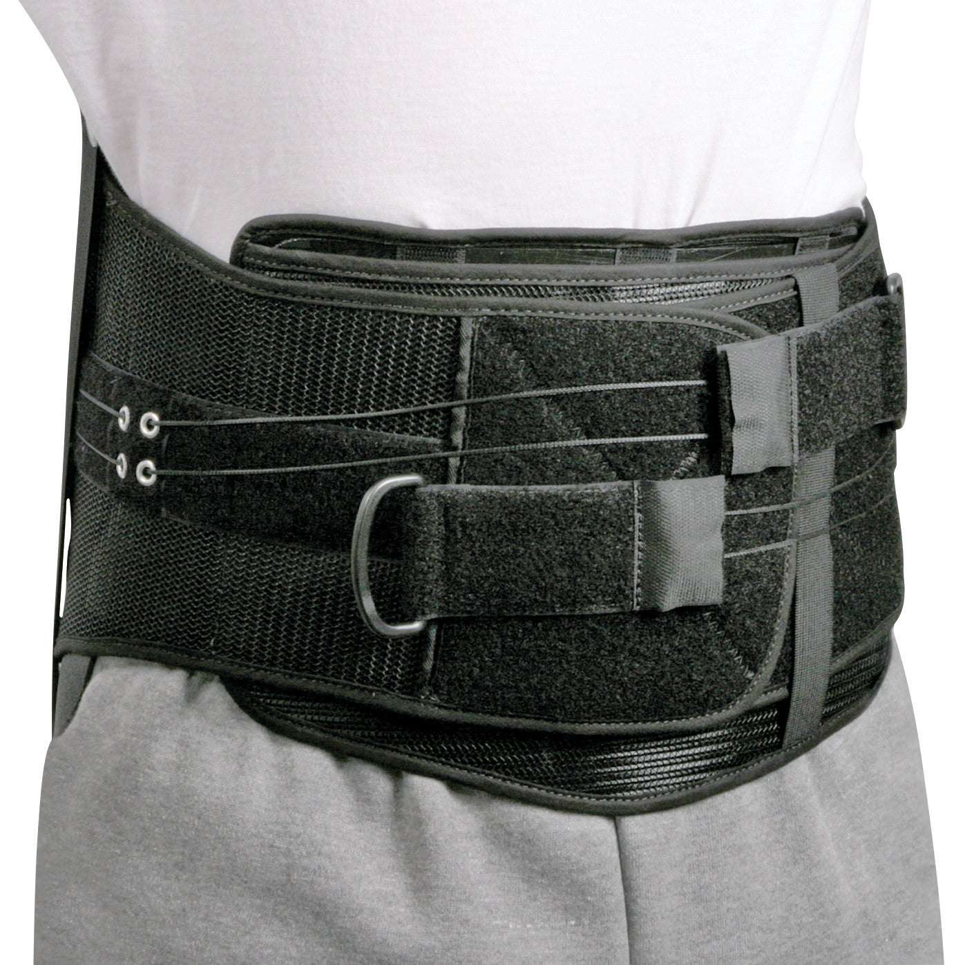 A person wears the AliMed Shadow Modular Spinal System, a black back brace with adjustable straps and hook and loop fasteners.
