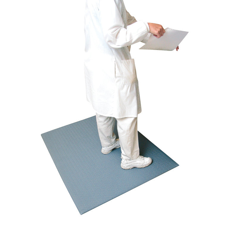 A person stands on a Comfort-King Antimicrobial Anti-Fatigue Mat, wearing a white coat and holding a clipboard.