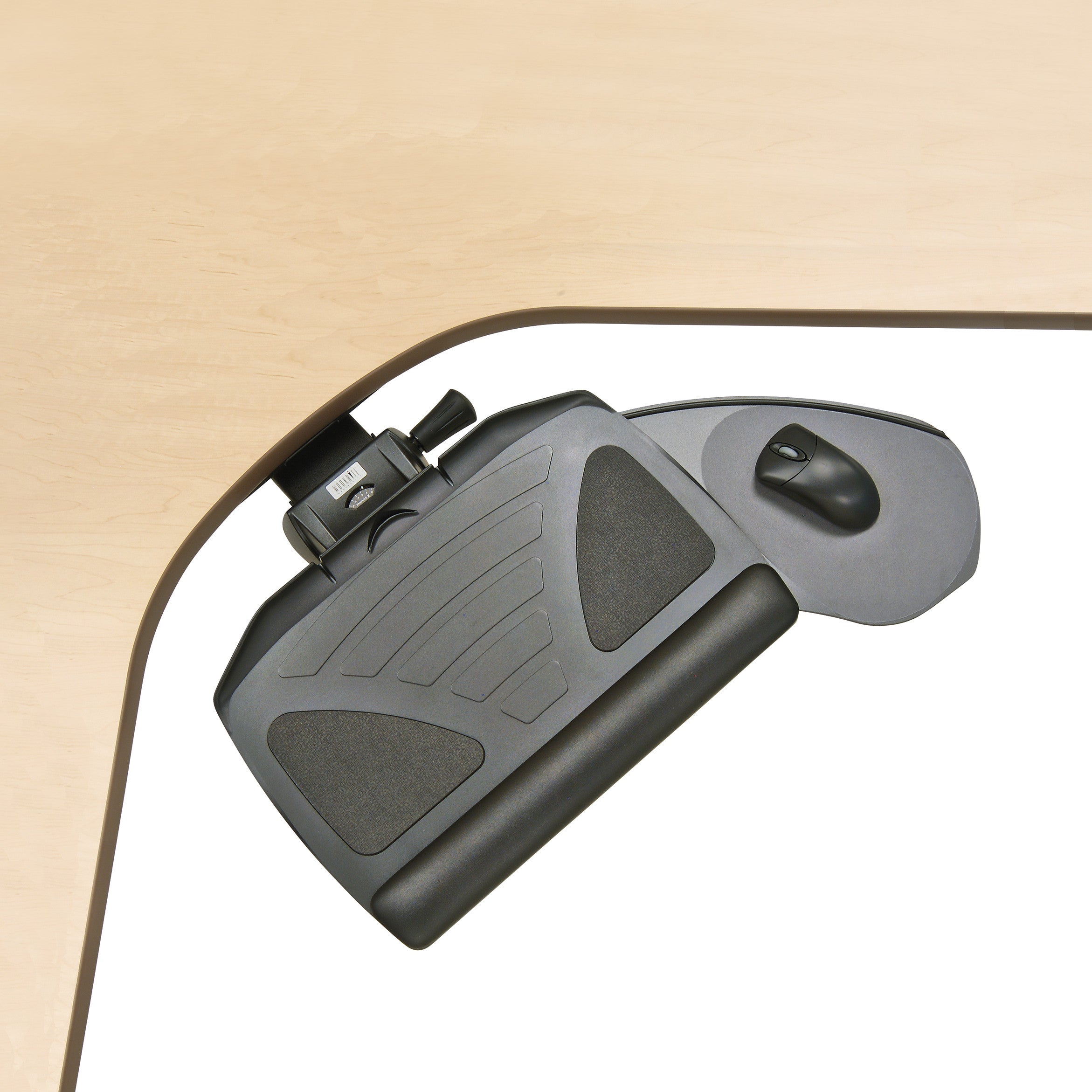 A Banana-Board Keyboard Tray with a mouse pad and wrist rest is attached under a wooden desk corner, positioned for ergonomic use.