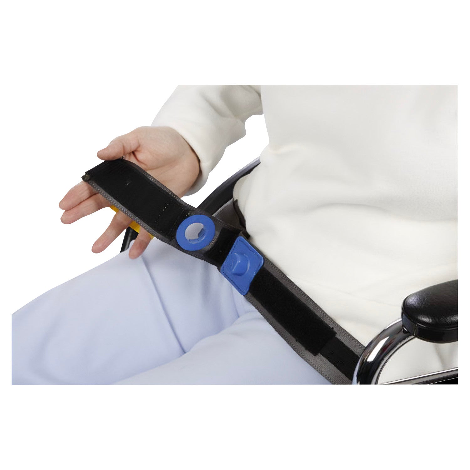 A person in a wheelchair uses an AliMed E-Z Release Seatbelt with a blue buckle for easy fastening and unfastening.