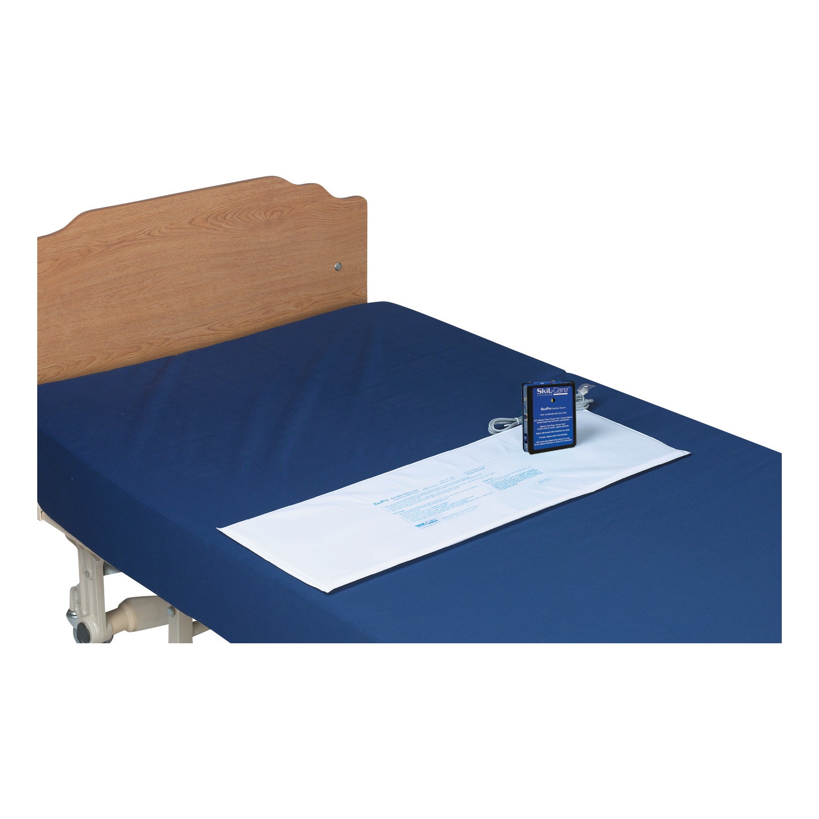SkiL-Care BedPro Safety Alarm System with Sensor Pad on a navy mattress, featuring a wooden headboard, for patient safety.
