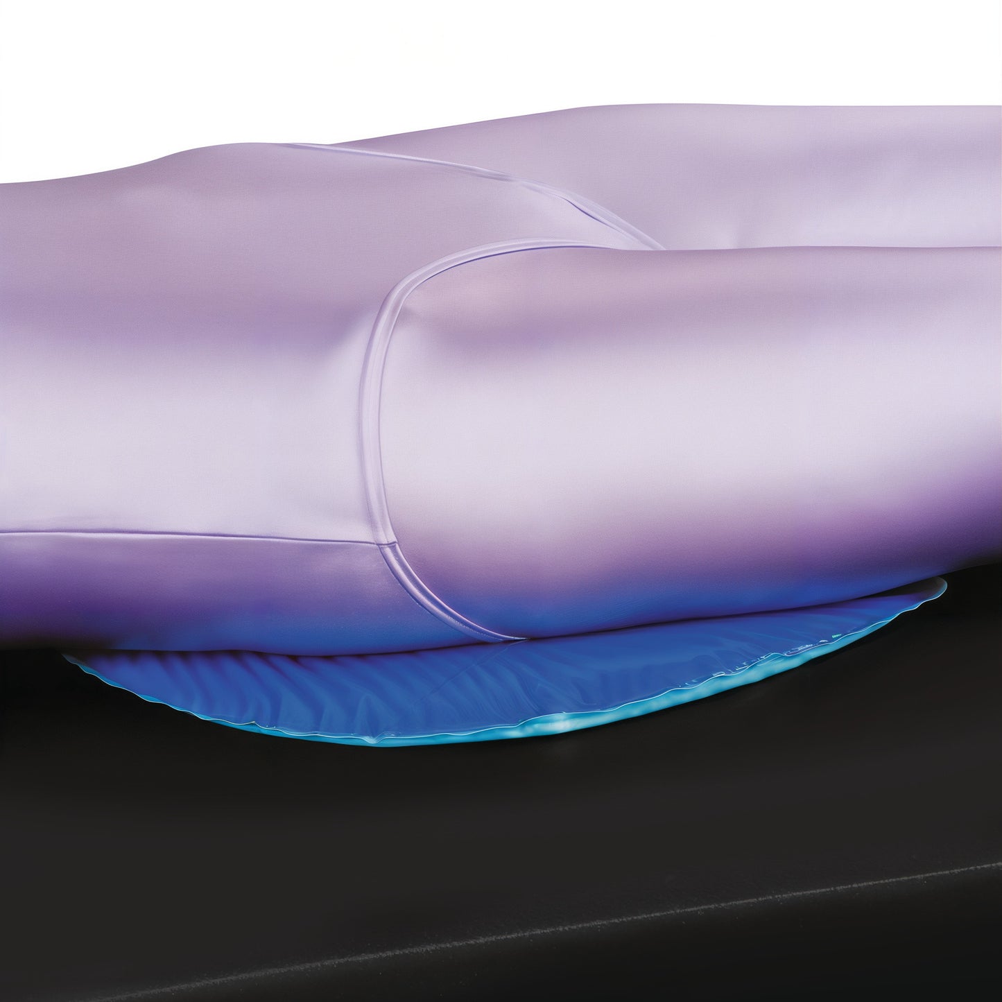 The Azure Sacral Protector is shown under a person's back on a black surface, providing cushioning and support.