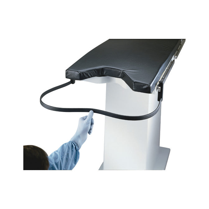 A gloved hand demonstrates the Uro-Catcher System, featuring a black cushioned platform on a stand with an attached support strap.