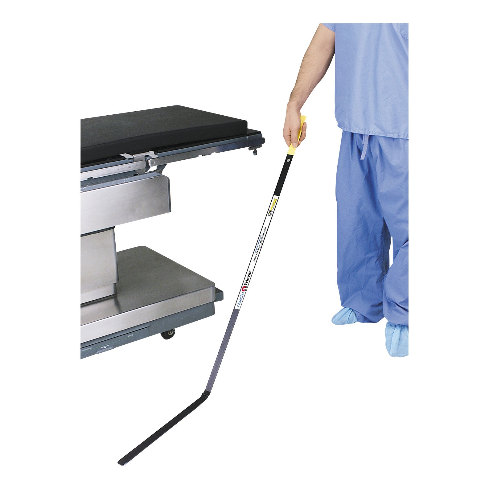 Person using the Allen Magnetic Needle Retriever, a long-handled tool, next to a metal table.