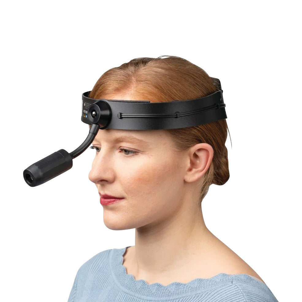 A person wearing a Riester ri-focus LED Exam Headlight with Rechargeable Battery Kit, featuring a black strap and front-mounted light.