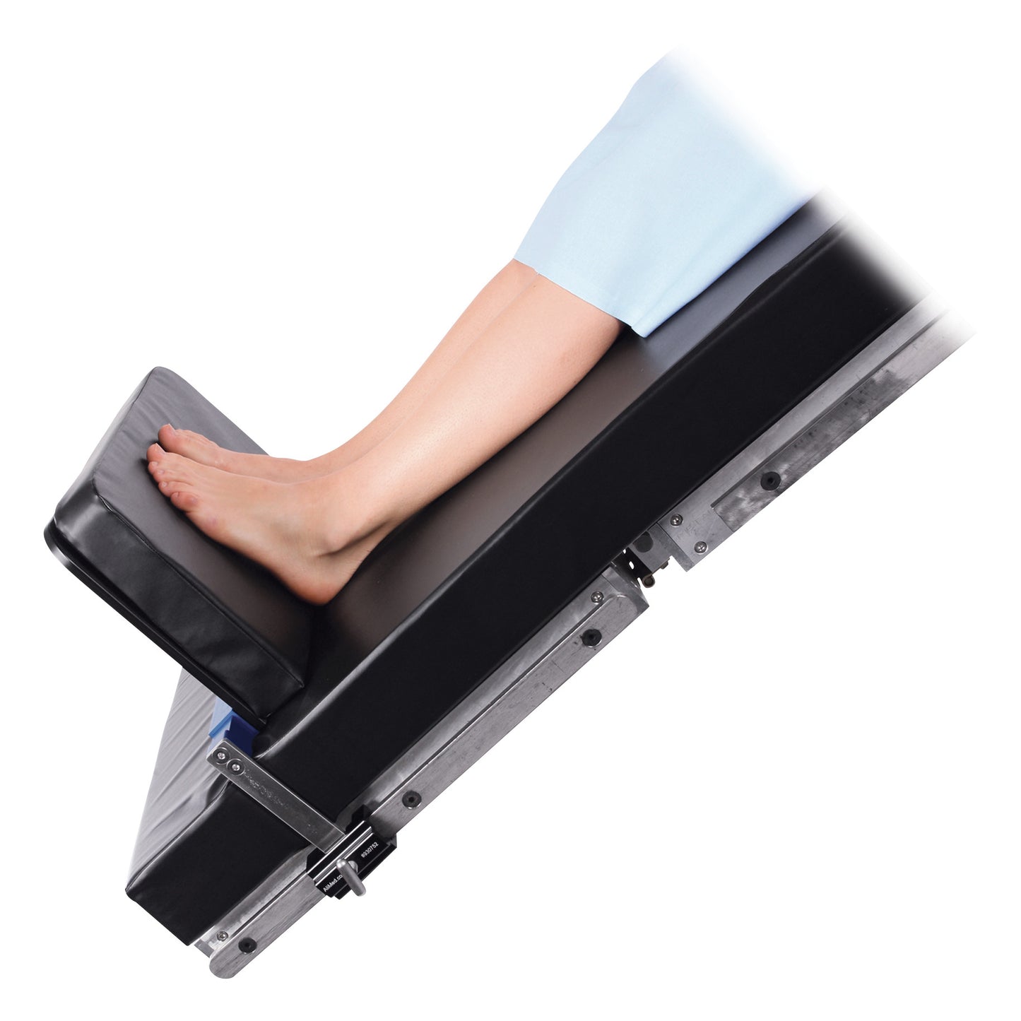 A person rests their feet on an angled AliMed Foot Extender, covered in black padding for support.