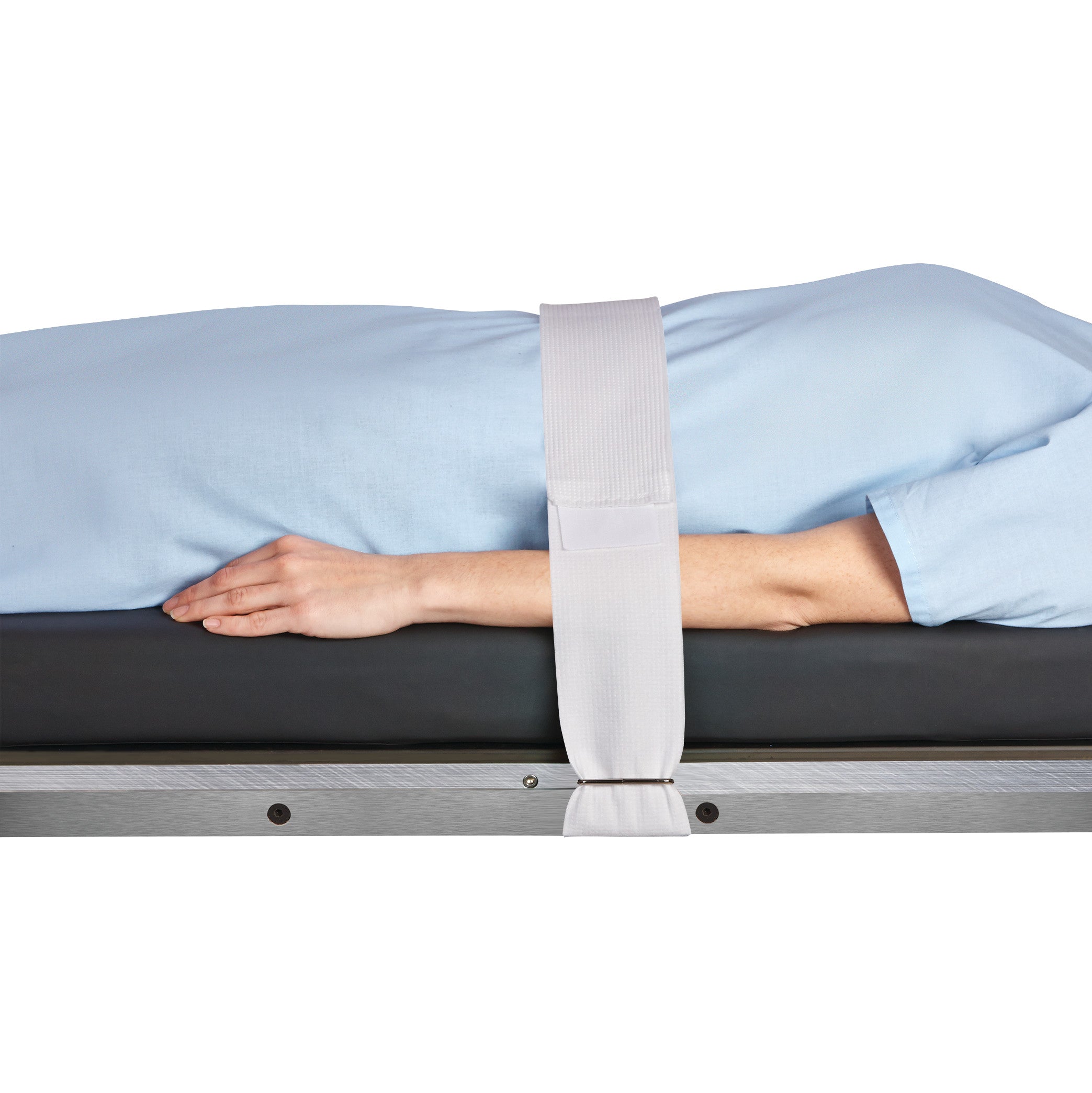 A person lies on a table secured with a Halyard Operating Room Table/Stretcher Strap over their body, wearing a light blue garment.
