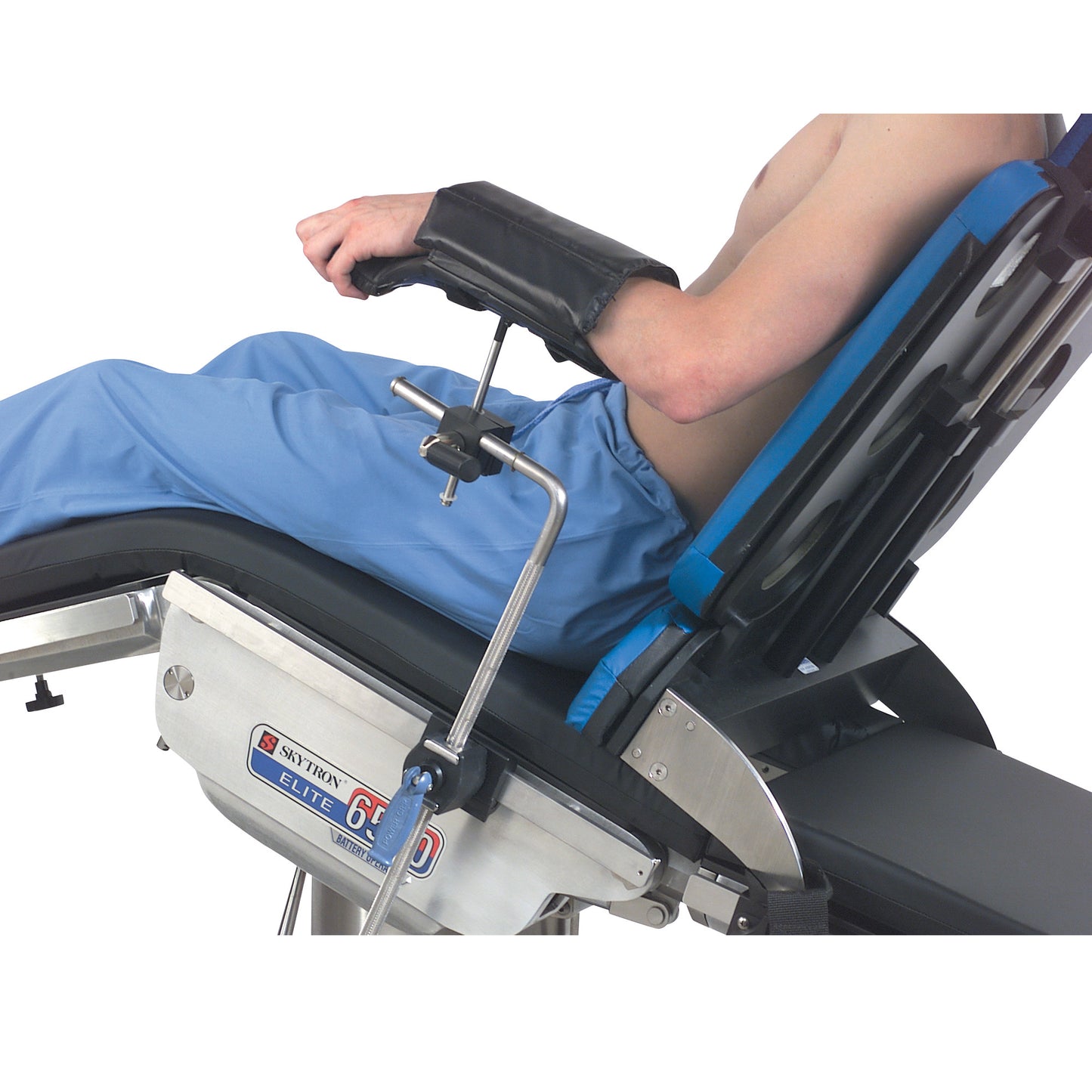 A person reclines on a medical chair with their arm secured on a Replacement Pad for Allen Lateral and Prone Arm Support.