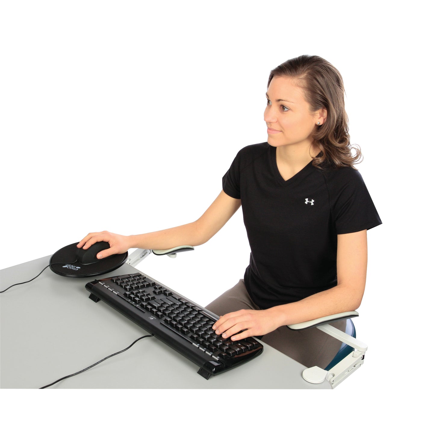A person uses a computer with the ErgoRest Articulating Forearm Support, positioned alongside a mouse and keyboard on a desk.