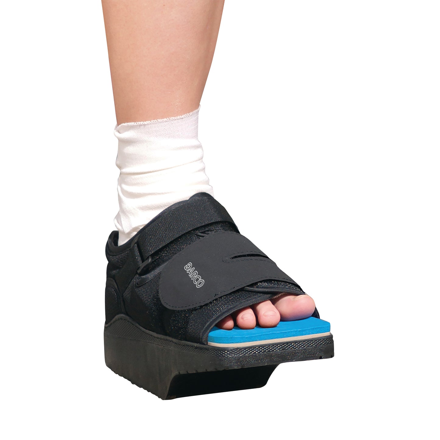 A person's foot is in a DARCO OrthoWedge Shoe with a blue sole, featuring a Velcro strap and white sock for post-operative care.