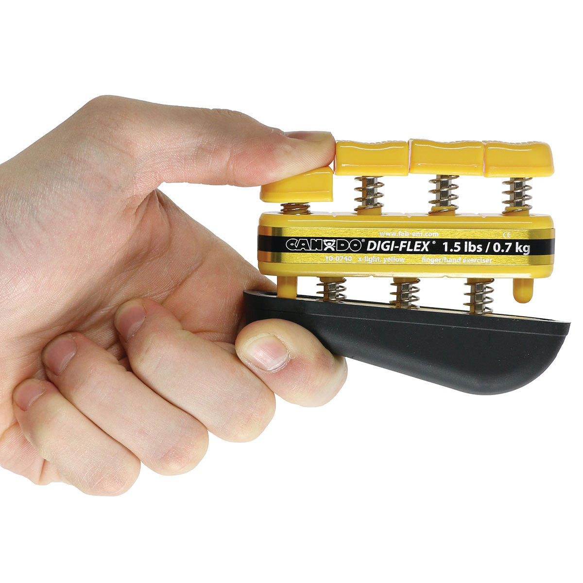 A hand uses the CanDo Digi-Flex Hand Exerciser, a yellow finger resistance tool labeled "1.5 lbs / 0.7 kg."