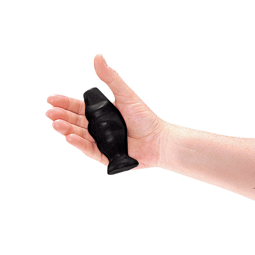 A hand holding the black AliMed Swanson Grip-X Hand Exerciser, a small tool designed for strengthening grip and hand muscles.