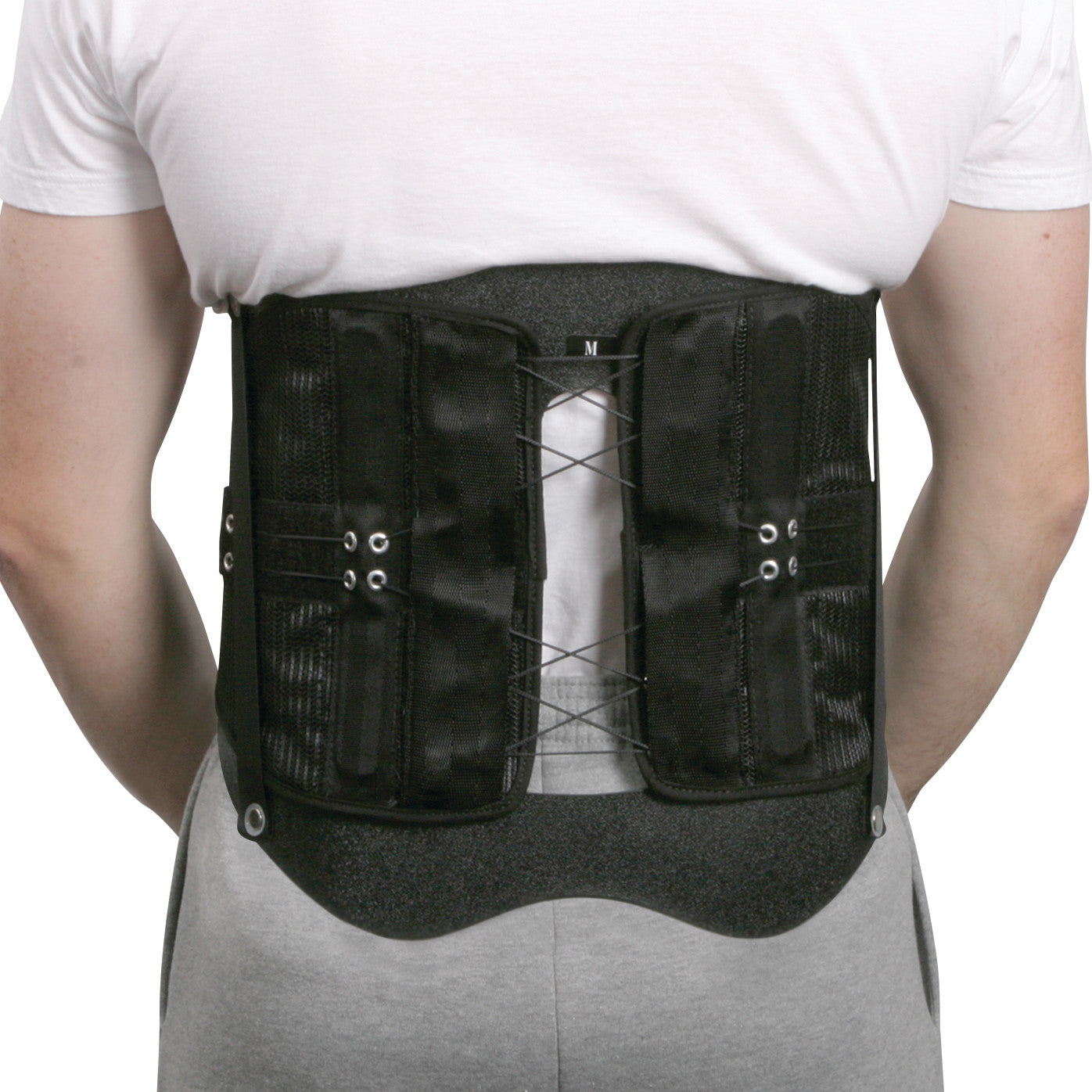 A person wearing the AliMed Shadow Modular Spinal System, a black back brace with adjustable lacing, over a white shirt.