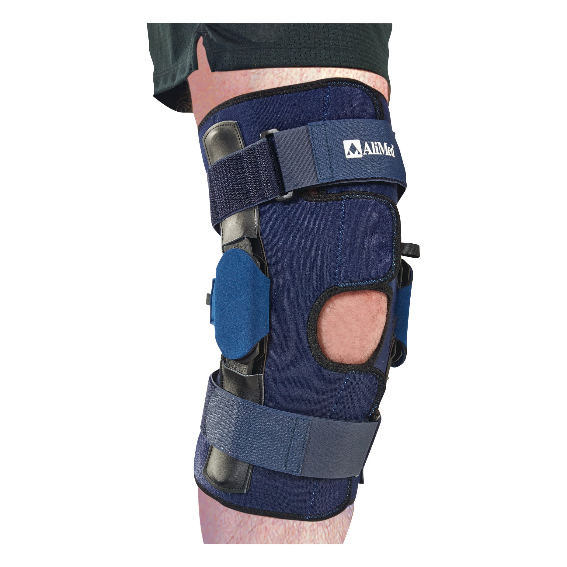 A person's leg is fitted with an AliMed Knee Brace with Multilock Polyamide Hinge, featuring adjustable straps and open patella design.