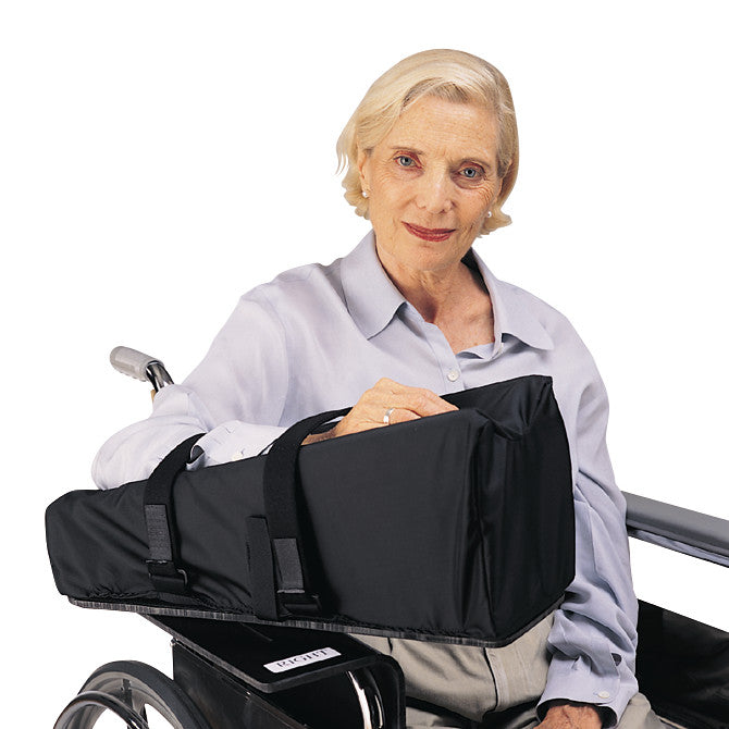 An older adult in a wheelchair using a SkiL-Care Elevated Wheelchair Mobile Arm Support, with a neutral expression.