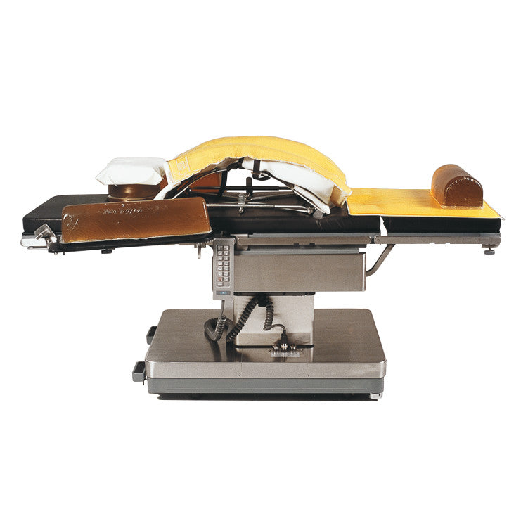 A surgical table features the AliMed AliGel Wilson Pad Set with a yellow curved support, brown armrest, and headrest attachments.