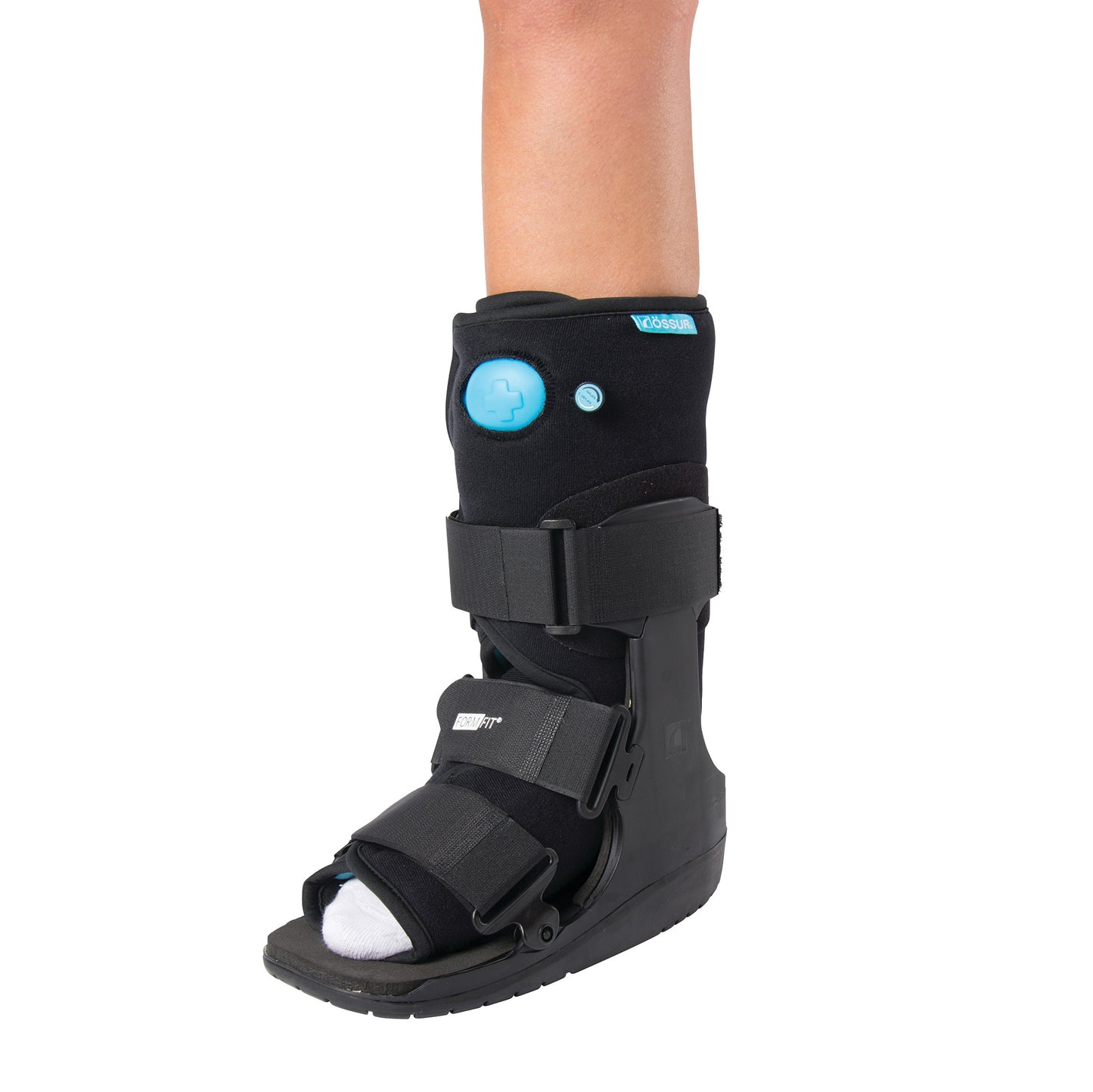 A person wears an �ssur Formfit Low-Top Air Walker on their lower leg, featuring adjustable straps and a black-and-blue design.