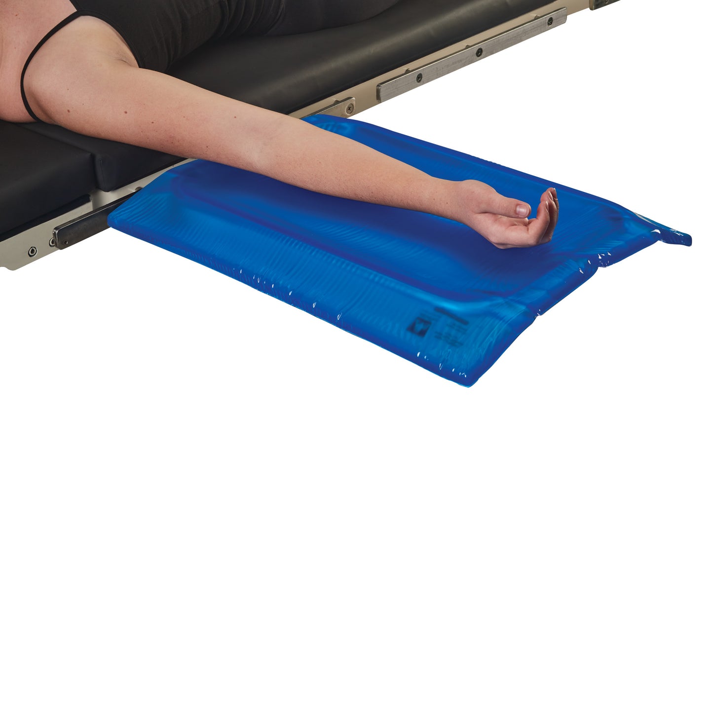 A person's arm rests on an AliMed AliBlue Gel Mayo Stand Cover, placed at the edge of an examination table.