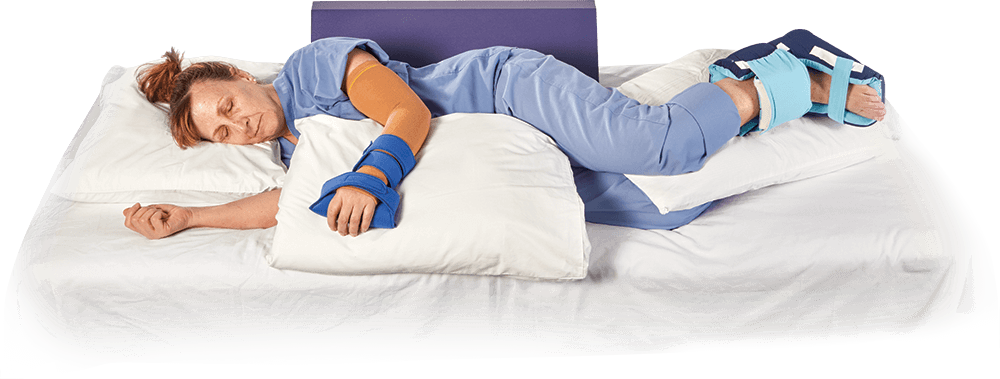 person laying on bed with pillows under arm and legs