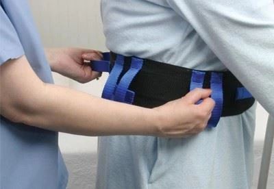 nurse putting gait belt on patient