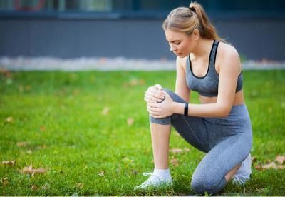woman holding knee after running
