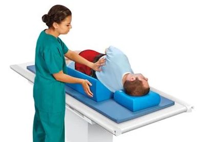 nurse putting positioning wedge on patient on operating table