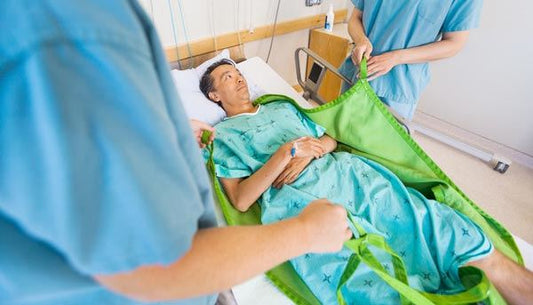 nurses using transfer sheet to transfer patient