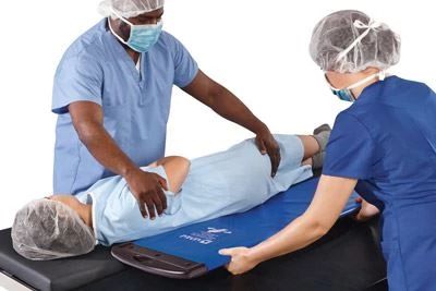 nurses using soft rollboard to transfer patient