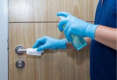 nursing spraying and wiping down door handle