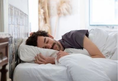 man lying in bed on his side