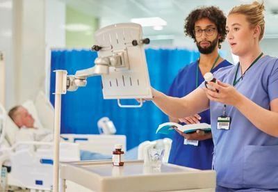 nurses checking medication label on computer