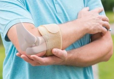 person holding elbow with bone graphic
