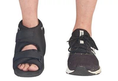 person wearing sneaker and post op shoe