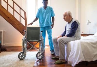 nurse getting ready to transfer patient from bed to wheelchair