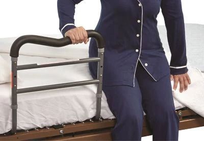 person using bed rail to get out of bed
