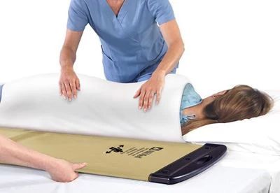 nurses putting patient on rollboard to transfer patient