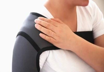 person wearing shoulder support while holding shoulder