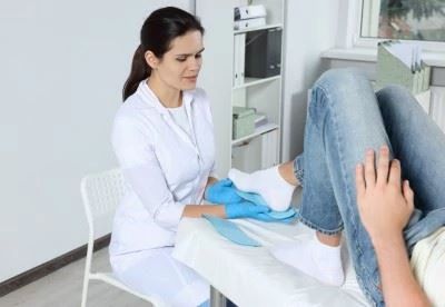 nurse fitting insole on patients foot
