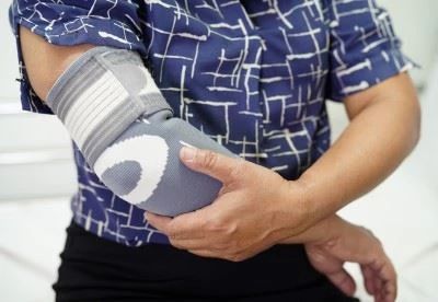 person holding their elbow with elbow brace on